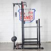 Vitox Fitness - Half power rack VR215: A sturdy black and red weightlifting structure with two vertical posts and adjustable safety bars. It includes a pull-up bar at the top and barbell hooks for squats and bench presses. The frame features multiple height adjustments, with safety arms and a compact design, suitable for home or gym use.